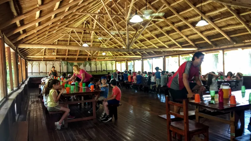 Chicos compartiendo el almuerzo en las mesas largas del quincho