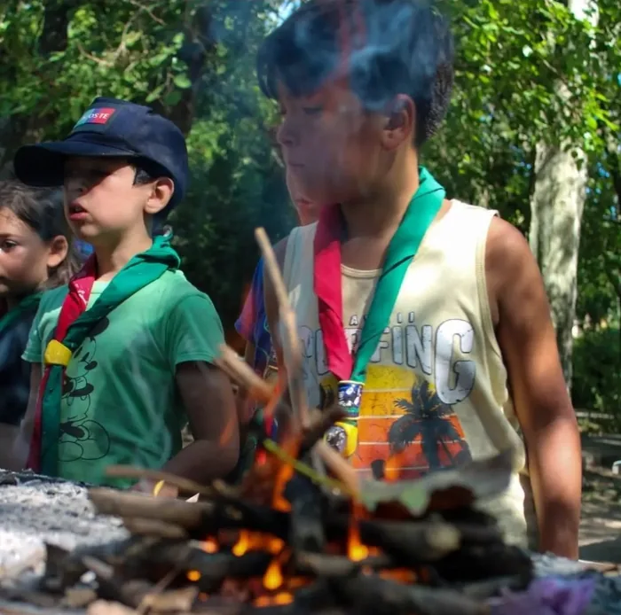 Chicos practicando cómo prender un fuego chico
