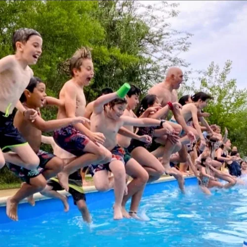 Un grupo de chicos salta junto a la pileta