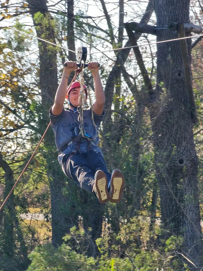Una persona cruzando en tirolesa entre los árboles